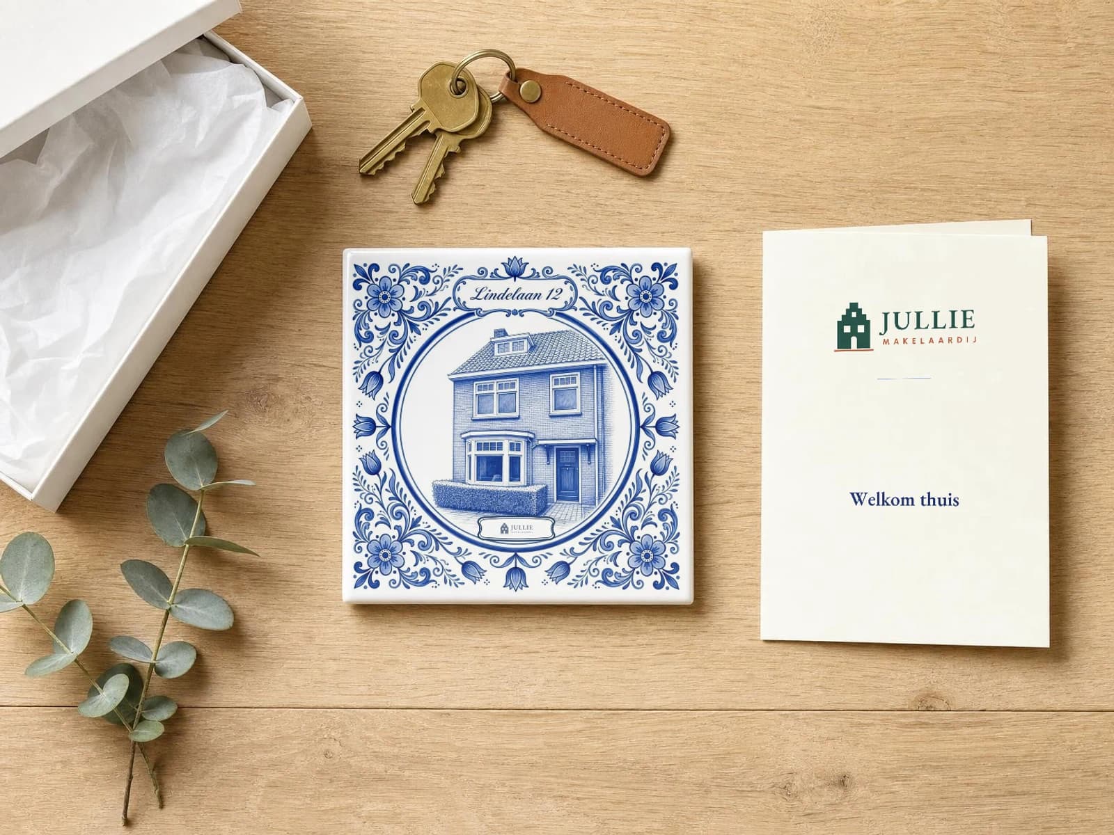 Delfts blauw tegeltje van een huis met sleutels en een kaartje van de makelaar